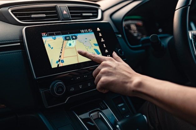 Photo hand using gps navigation system in car while travel