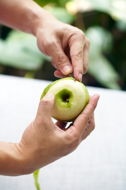 Hand using knife peeling apple skin