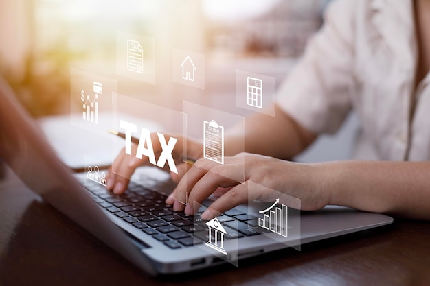 Photo hand using a laptop with tax refund and refund tax of duty taxation business graphs and chart being demonstrated on the screen media tablet pc and selecting tax refund saving tax for business