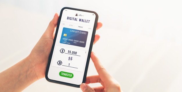 ビットコインからドルへの交換アプリケーションに携帯電話を使用する手。スマートフォンの画面にクレジットカードでのお支払いが表示されます。