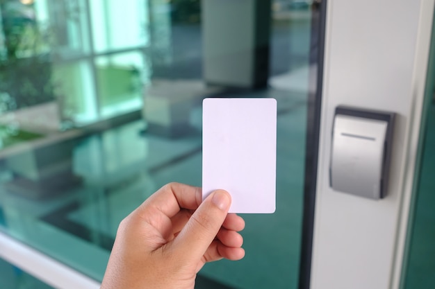 Photo hand using security key card scanning to open the door to entering office building or home or bank