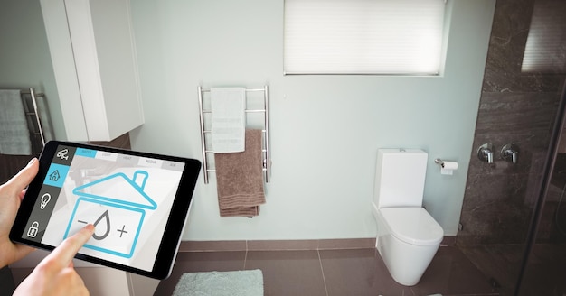 Hand using smart home application on digital tablet in washroom