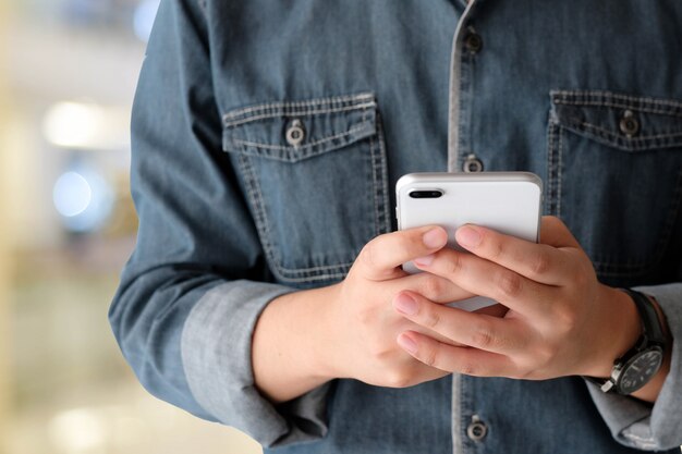 Hand using smart phone over blur bokeh light background