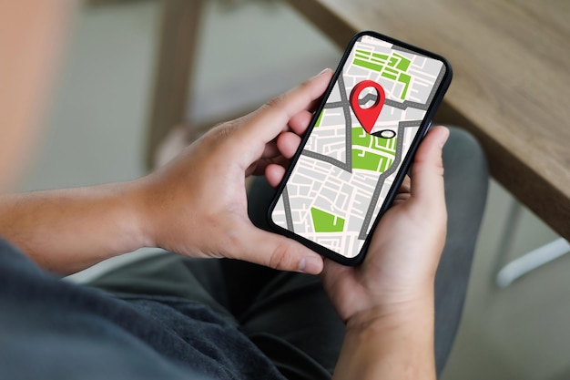 Mano usando uno smartphone tenendo la mappa gps verso il percorso connessione alla rete di destinazione posizione mappa stradale con icone gps navigazione