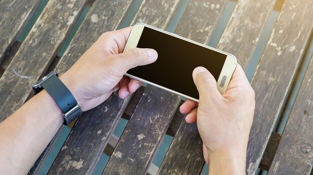 Hand using a smartphone and a smartwatch.