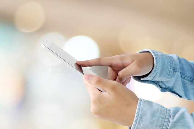 Hand using tablet over blur store with bokeh light background, banner, business and technology concept, digital marketing, seo, e-commerce