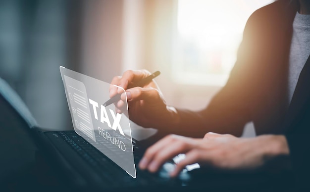 Hand using tablet with bar TAX REFUND and refund tax of duty taxation business graphs and chart being demonstrated on the screen media tablet pc and selecting tax refund