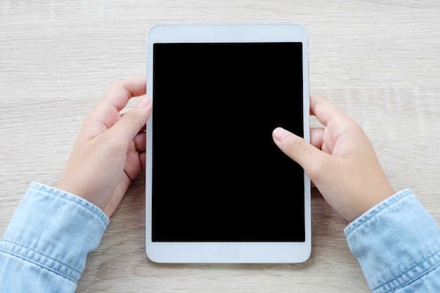 Hand using tablet with on wood table background, mock up, template, top view