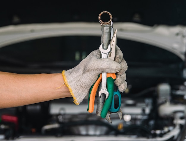 Hand van automonteur met moersleutel automonteur Reparatieonderhoud en auto-inspectie