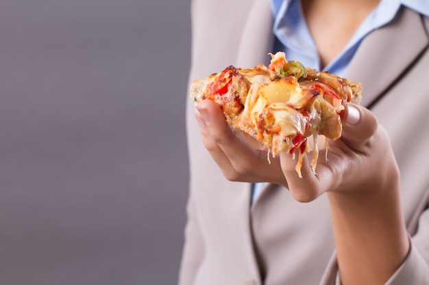 Hand van Aziatische vrouw met een stuk pizza