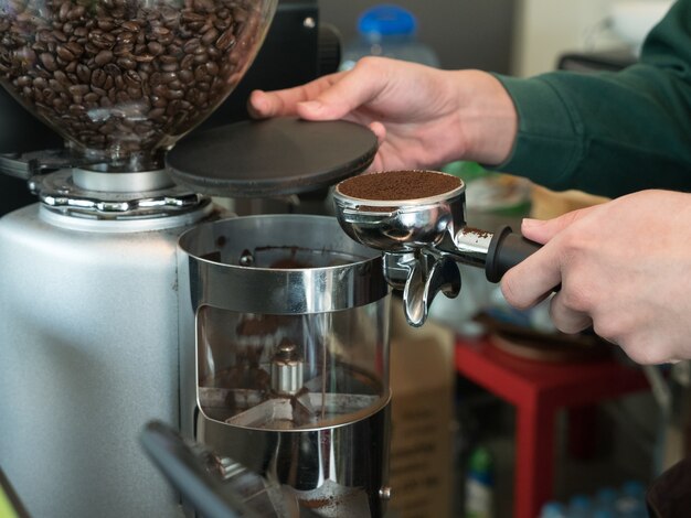 hand van barista koffie met koffiemachine in de koffiewinkel maken