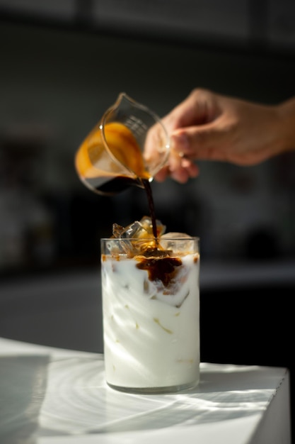 Hand van Barista schonk koffie in een glas