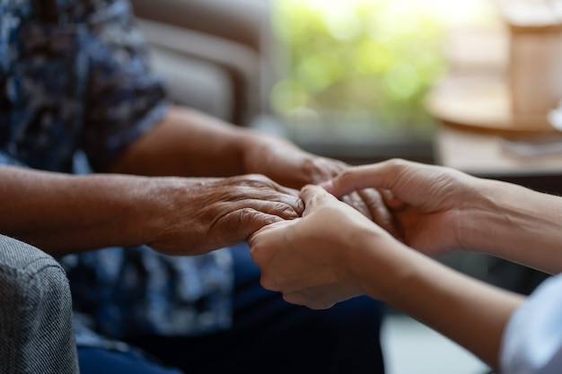 Hand van bejaarde vrouw hand jongere vrouw, helpende handen, wees voorzichtig