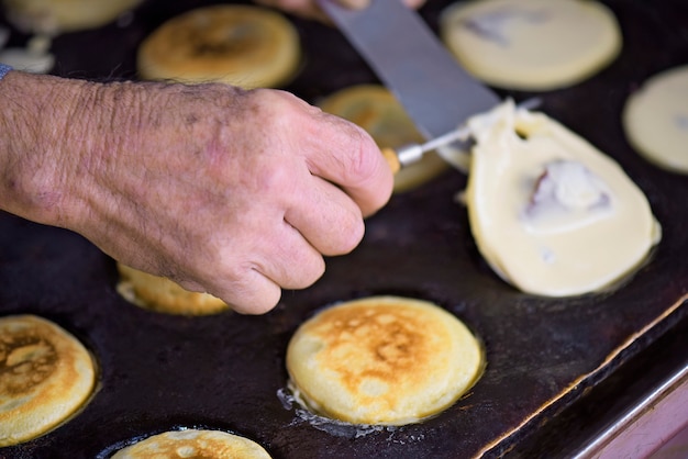 Hand van de mens die imagawayakicake voorbereiden