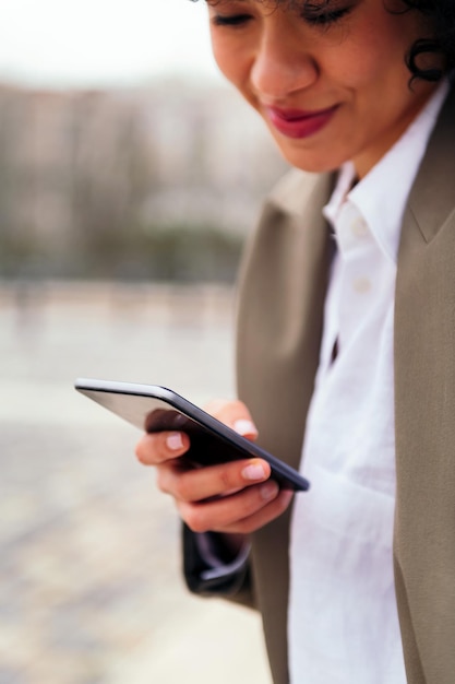 Hand van een jonge latijnse vrouw die een mobiele telefoon gebruikt