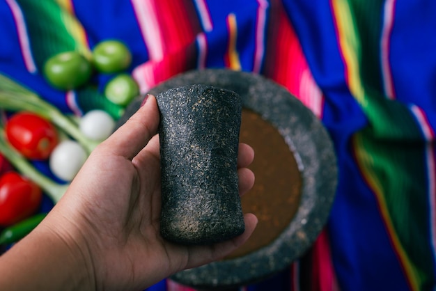 Foto hand van een persoon die de molcajete temolote laat zien