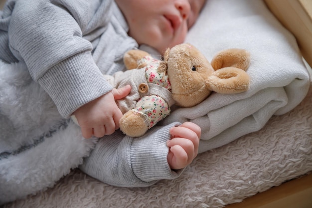 Hand van een slapende baby met een speeltje