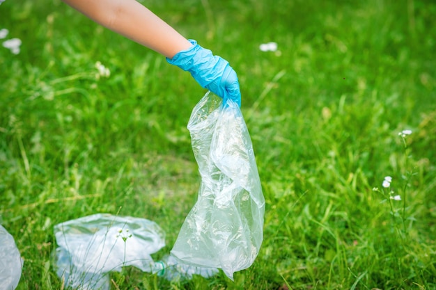 Hand van kind reinigt het park van plastic afval