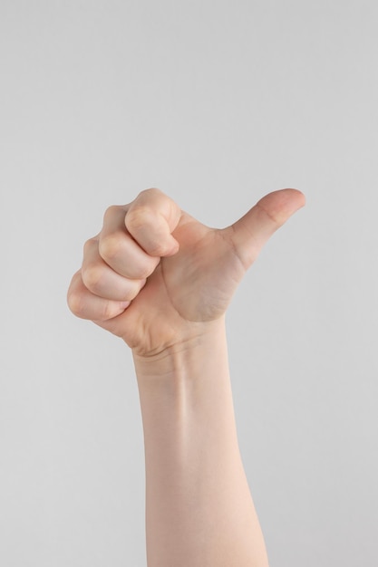 Foto hand van kinderen of kind hand duimen opdagen geïsoleerd op een witte en grijze achtergrond