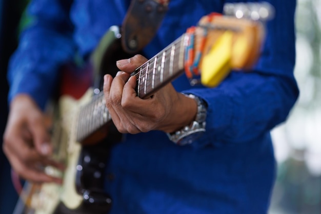 Hand van man die op elektrische gitaar speelt Een onherkenbare muzikant-gitarist die muziek uitvoert met een instrument