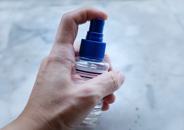 Hand van mensen die alcoholspray of antibacteriële spray toepassen om verspreiding van ziektekiemen, bacteriën en virussen te voorkomen.