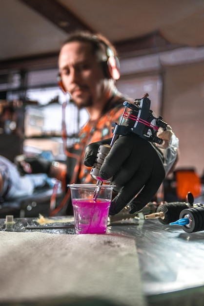 Hand van professionele tatoeëerder met een tattoo-pistool