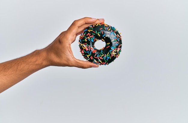 Hand van spaanse man met chocolade donut over geïsoleerde witte achtergrond