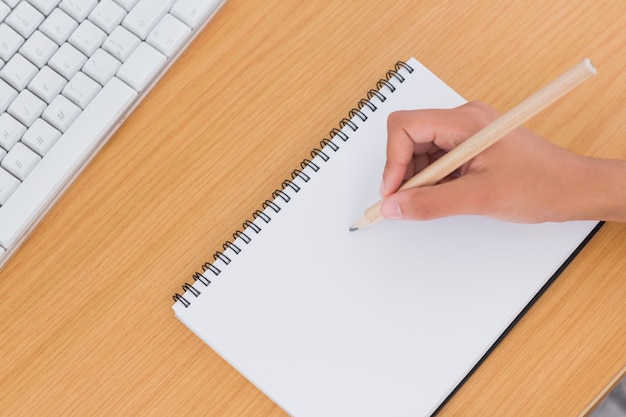 Hand van vrouw die op een document op een bureau trekt