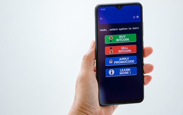 Hand vasthouden en tonen van smartphonescherm met codeknoppen voor kopen en verkopen in cryptocurrency