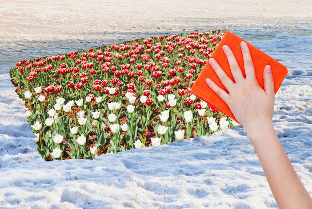 Hand verwijdert sneeuwoppervlak door oranje doek