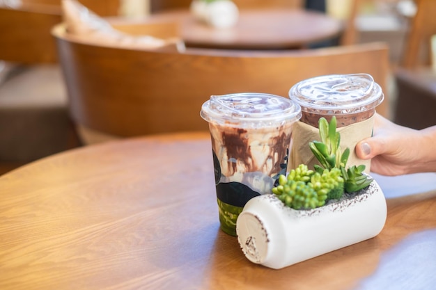 Hand vrouwen met een kopje koffie op houten tafel in coffeeshop ontspannen tijd in vakantie