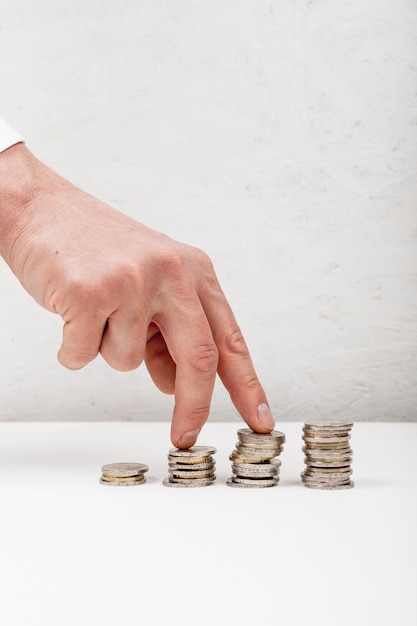 Photo hand walking on pile of coins