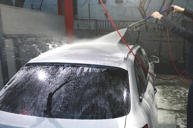 Hand washing with high pressure water spraying water on the car Selfservice car wash