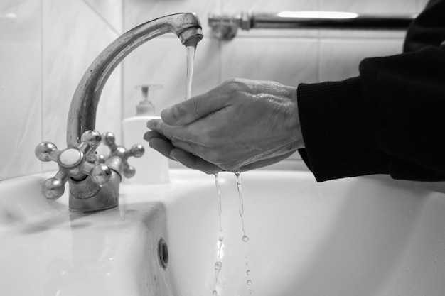 コロナウイルスを防ぐために石鹸と水で手洗いする手洗い白黒写真