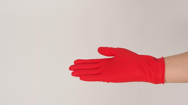 Hand wear red latex gloves on white background.