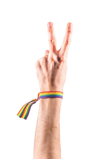 Hand wearing a bracelet with the colors of the LGBT flag showing two fingers