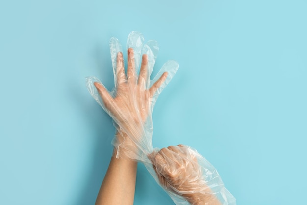 Hand wearing disposable plastic glove isolated on color background