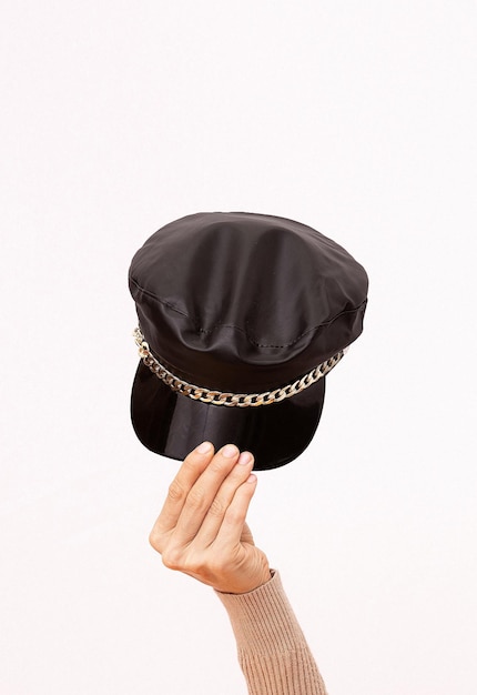 Hand on white background holds fashion black cap Style in details Minimalist Trendy Head accessory