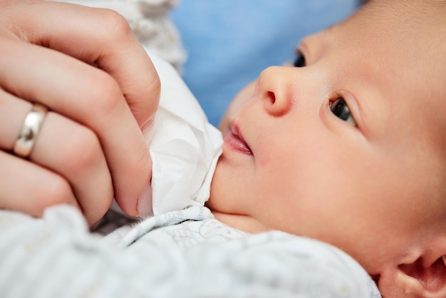 Hand wipes new born baby face with a napkin