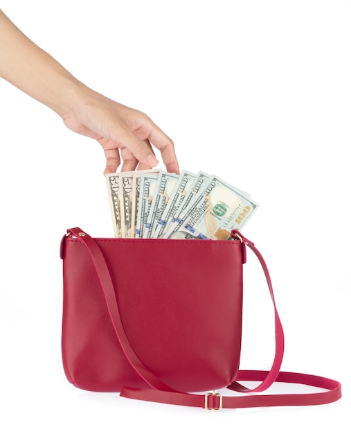 Photo hand with 100 american dollars in red leather female handbag isolated on white background