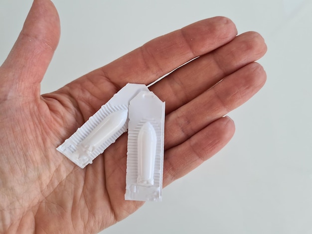 Hand with anal suppositories in hand closeup