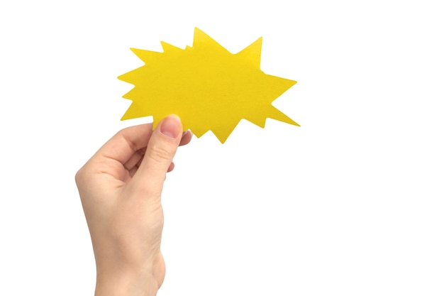 Hand with blank speech bubble in shape of boom or lightning, yellow color, isolated on a white background. Concept of giving feedback, communication and text message. Empty cardboard mockup photo