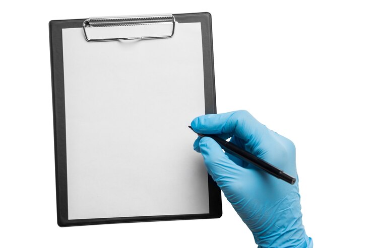 Photo the hand with the blue glove writes on a clipboard on a white background