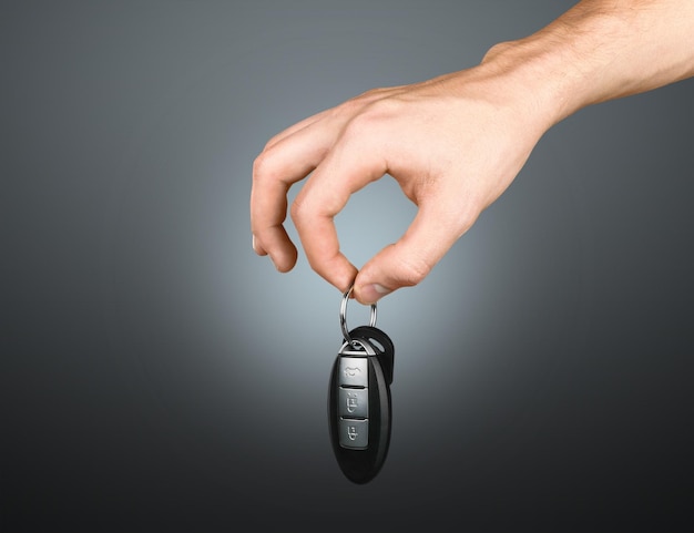 Hand with a car key. Isolated on background.