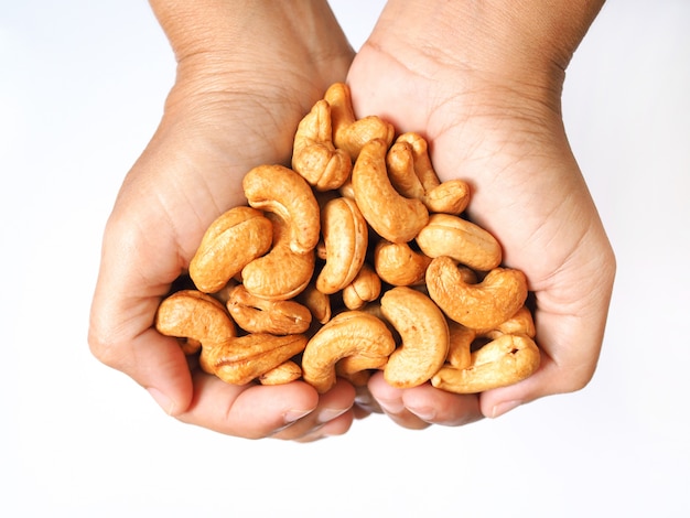 above of hand with cashew nuts.