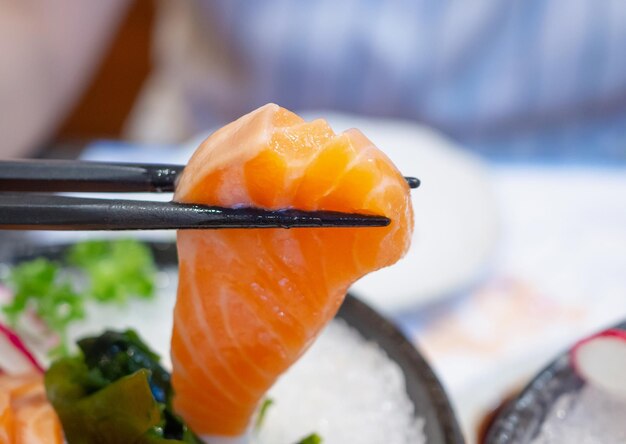 箸で手に鮭刺身日本食を握る