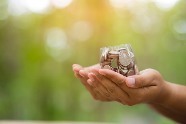 Hand with coins on bokeh background