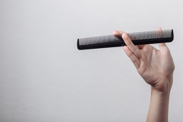 Hand with a comb on a white background