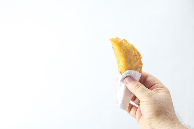 Hand with a corn empanada typical Colombian food with copy space