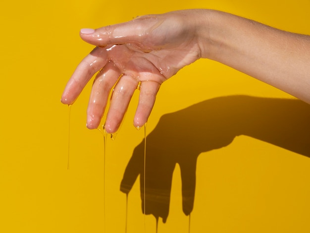 Hand with dripping honey studio shot